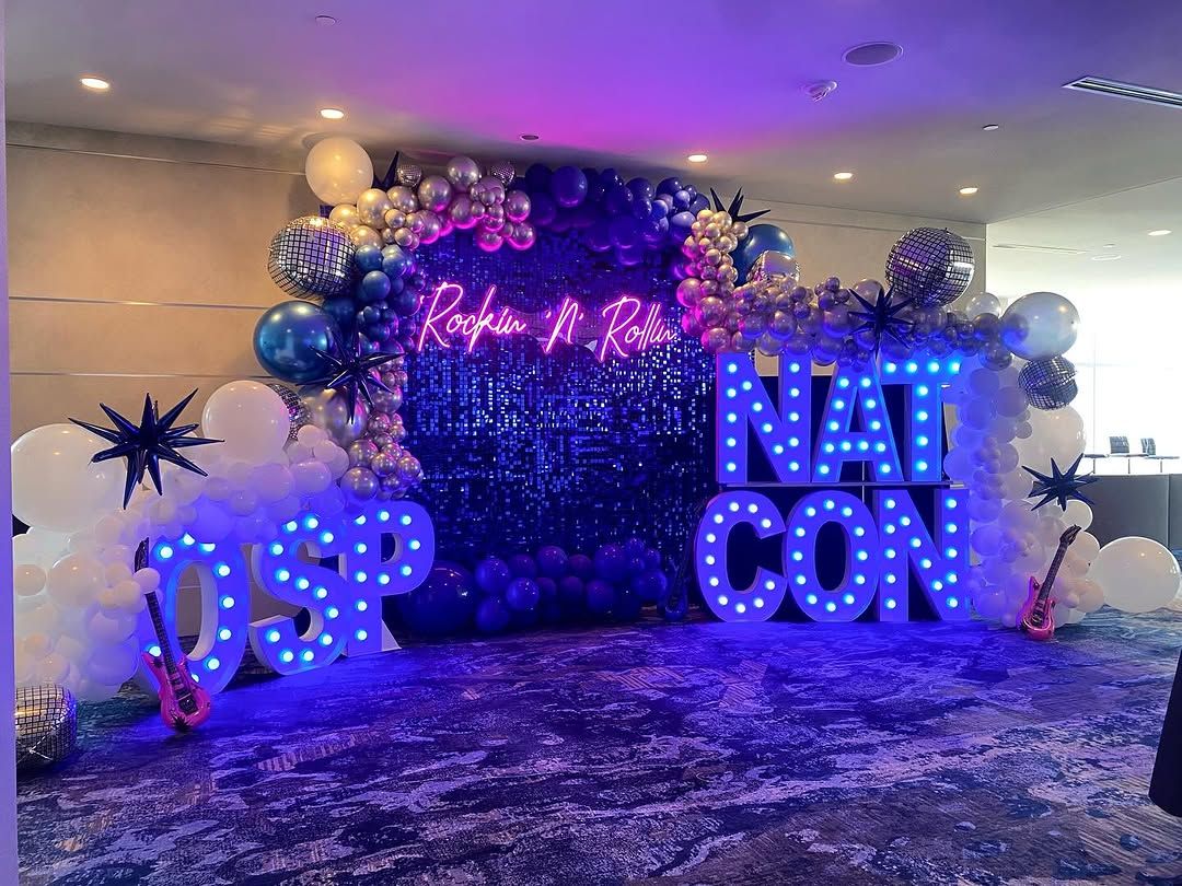Purple and blue rock themed conference setup with balloon arch