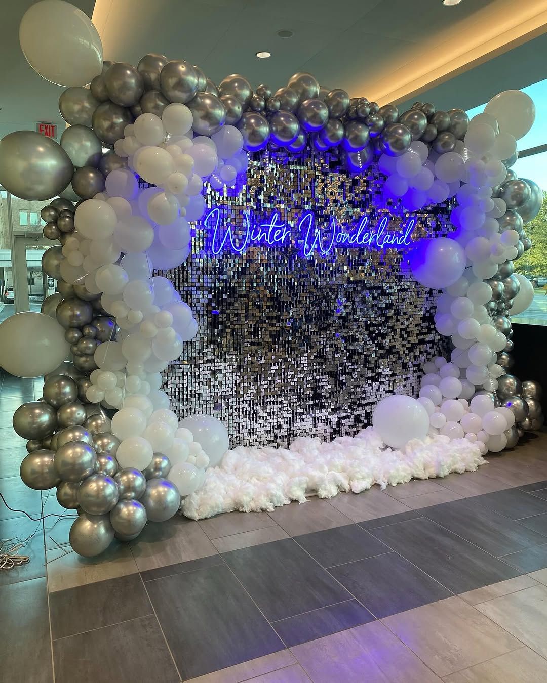 Winter wonderland themed setup with silver balloons and sequin backdrop